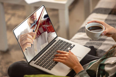 Close-up young woman learning play on musicial instruments online.