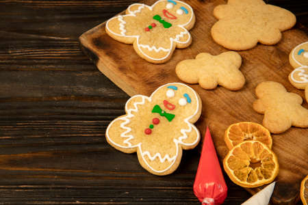Cute gingerbread men on a wooden background. Christmas and New Year concept.