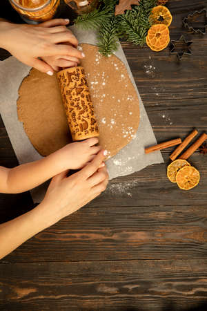 Top view close-up child and woman hands making festive cookies with rolling-pin.の写真素材