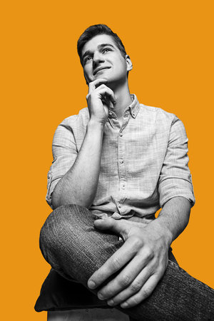 Black and white portrait of handsome young man isolated over yellow background.の写真素材