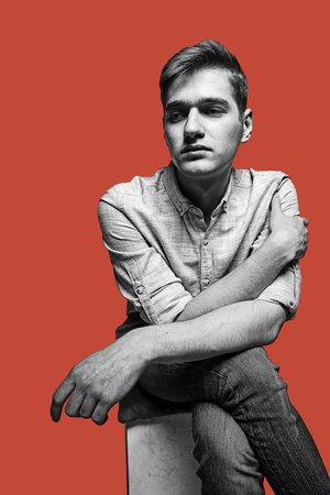 Black and white portrait of handsome young man isolated over brown background.の写真素材