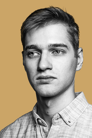 Black and white portrait of handsome young man isolated over yellow background.