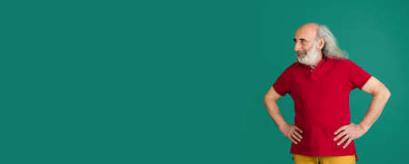 Half-length portrait of senior grey-haired man isolated over green background.の写真素材