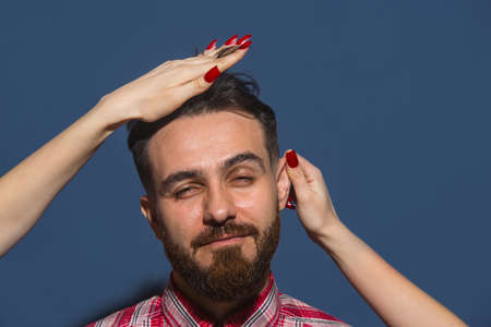 Half-length portrait of young Caucasian man isolated over blue background.の写真素材