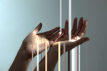 Light rays passing through human hands isolated on light grey background.