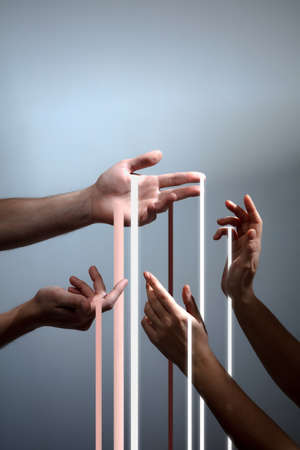 Streaks of light trickle down of beautiful hands isolated over grey background.の写真素材