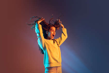 Portrait of young beautiful girl isolated on gradient background in neon light