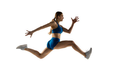 Young woman track athlete training isolated over white studio background.の写真素材
