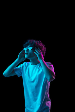 Portrait of Caucasian man isolated on dark multicolored background in neon light