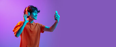 Young man talking on phone isolated over pink purple background in neon light