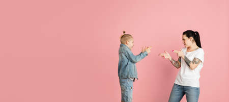 Happy woman and little boy, mother and son isolated over pink background.の写真素材
