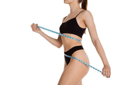 Cropped slim tanned beautiful woman in underwear isolated over white background.の写真素材