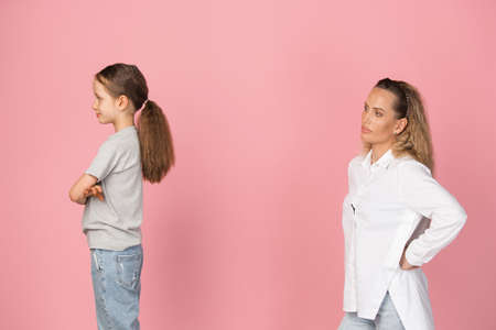 Two people, mother and daughter isolated over pink background.の写真素材