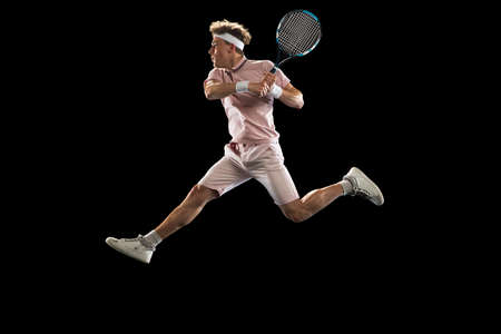 Young Caucasian man, professional tennis player isolated on black background.の写真素材