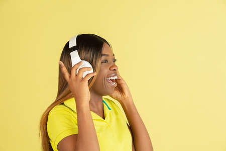 Portrait of African young woman posing isolated on yellow background.