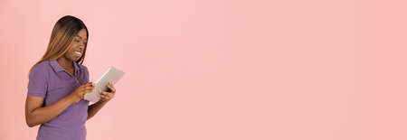 Flyer. Portrait of African woman posing isolated on pink background.