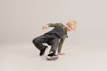 Little boy isolated over gray studio background. Childhood, education concept