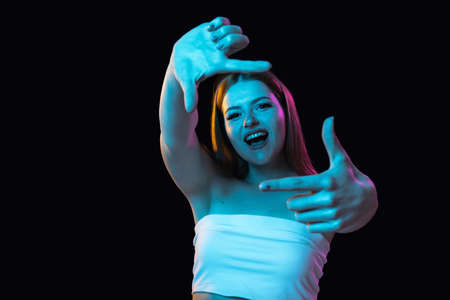 Close-up young beautiful girl gesturing isolated over dark background.の写真素材