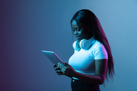 Portrait of young beautiful girl isolated over dark background in neonの写真素材