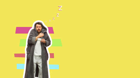 Caucasian man in bathrobe with cup of coffee isolated on yellow background