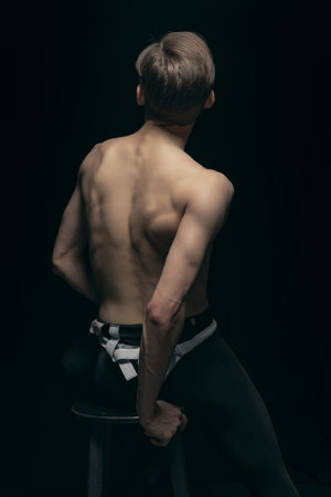 Portrait of young handsome man, fashion model posing isolated on dark background. Beauty, fashion, inspiration concept.の写真素材