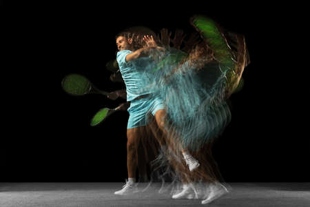 Stroboscope effect. One man, professional tennis player isolated on black background in mixed neon...