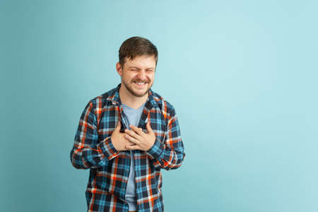 Funny young Caucasian bearded man in casual clothes isolated on light blue background. Having fun.
