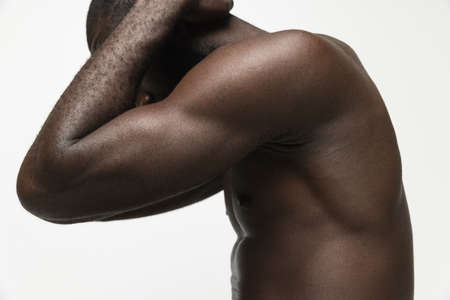 Cropped portrait of young handsome muscled African man posing isolated over white background. Sexy and stylish. Concept of beauty, cosmetics, spa, well kept skin. Copy space for ad, designの写真素材