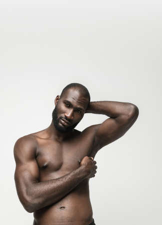 Young handsome muscled African man posing isolated over white background. Concept of beauty, cosmetics, spa.の写真素材