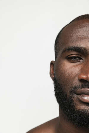 Cropped face of young African man isolated over white background. Concept of beauty, spa, well kept skin.の写真素材