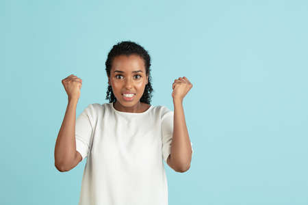 Flyer. Portrait of young beautiful girl in casual clothes isolated on light blue background.