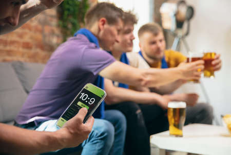 Side view. Young men watching TV, sport match together. Concept of friendship, leisure activity,...
