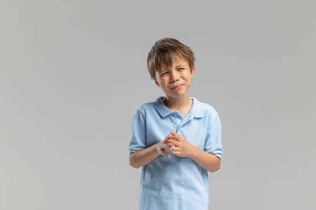 Half-length portrait of Caucasian little boy posing isolated over gray studio background.の写真素材