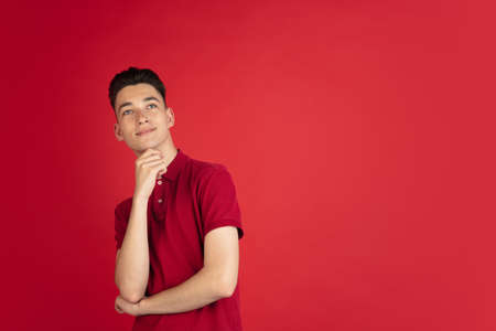 One young Caucasian boy isolated on red studio background. Concept of facial expressions, human emotions.の写真素材