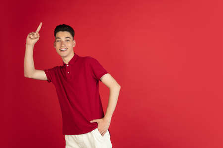 One young Caucasian boy isolated on red studio background. Concept of facial expressions, human...
