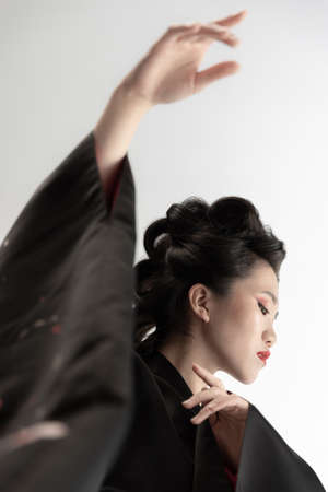 Portrait of young beautiful Japanese, woman in national attire kimono posing isolated over white studio background.の写真素材
