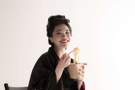 Portrait of young beautiful Japanese, woman in national attire kimono posing isolated over white studio background.の写真素材