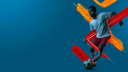 Young man, soccer footbal player training isolated in neon light background.の写真素材