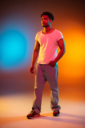Portrait of a young african man at studio. High Fashion male model in colorful bright neon lights. Art design concept.の写真素材