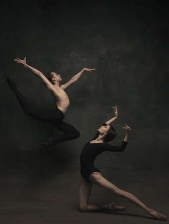 Beautiful graceful woman and man, ballet dancers in art performance dancing isolated over dark backgroundの写真素材