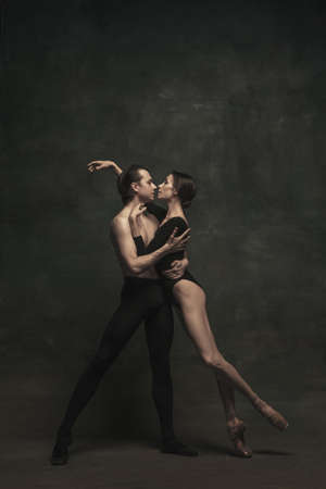 Beautiful graceful woman and man, ballet dancers in art performance dancing isolated over dark backgroundの写真素材