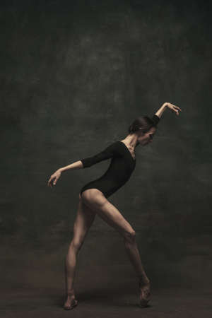 Young beautiful ballerina in action isolated over blue background. Concept of beauty, art, show, theater.の写真素材