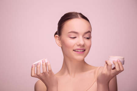 Portrait of beautiful young woman isolated on light pink studio background. Concept of female beauty, face skin careの写真素材