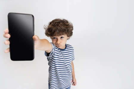 Portrait of little preschool boy posing isolated over white studio background.