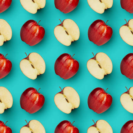 Halves and whole red juicy apples over bright blue background. Contemporary art collage.の写真素材