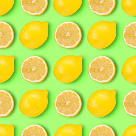 Crazy lemons. Halves and whole juicy yellow lemons arranged over vibrant light green background.の写真素材