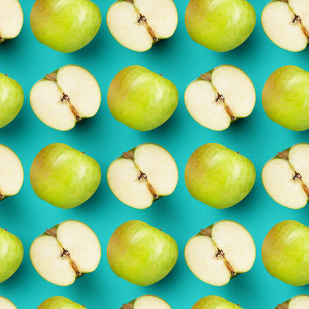 Halves and whole green juicy apples over bright blue background. Contemporary art collage.の写真素材