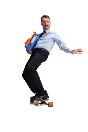 Front view. Portrait of young Caucasian man, office worker on skateboard isolated on white background.の写真素材