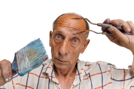 Mature or senior grey painter with a brush standing in front of camera. Funny man in a paint-stained...