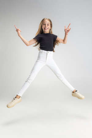 Portrait of teen school caucasian girl in casual clothes posing isolated over white studio...